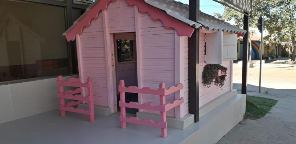 a pink play house with two chairs outside of it at Tapindaré Hotel in Alto Paraíso de Goiás