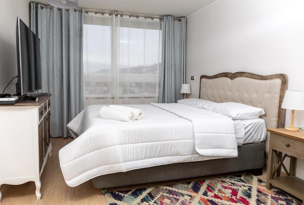 a bedroom with two beds and a tv and a window at Viña Retreat - 2BR W / Pool, Wifi & Parking in Viña del Mar