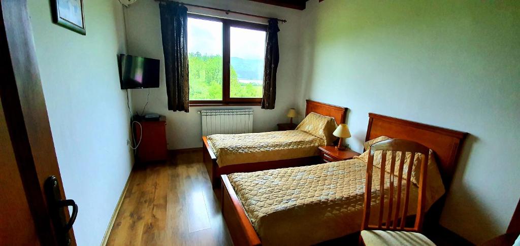 a bedroom with two beds and a window at Complex Pristan in the mountain in Shilkovtsi