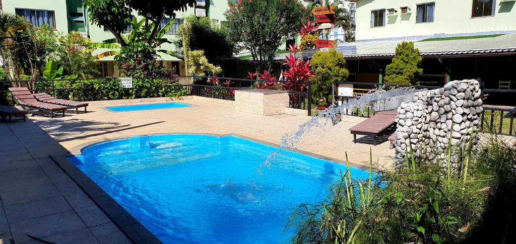 una gran piscina azul con una fuente en un patio en Duas Praias Hotel Pousada, en Guarapari