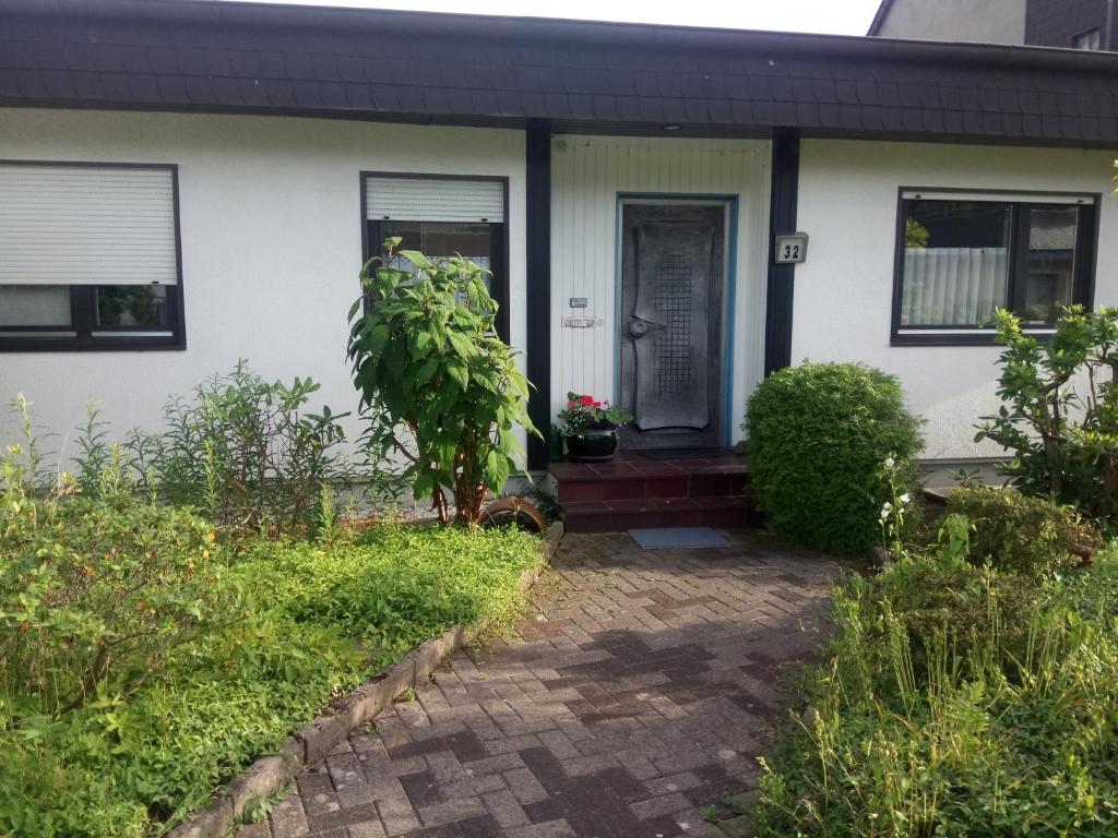 a white house with a door and a brick driveway at WenneGlück in Meschede