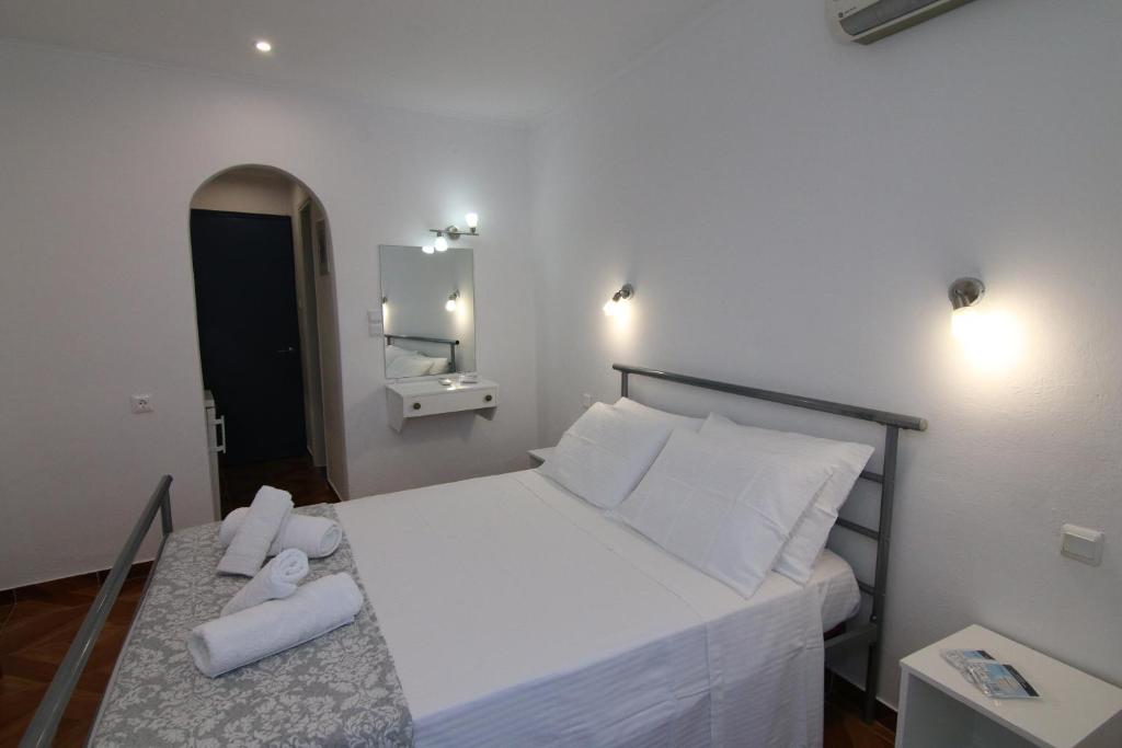 a bedroom with a large bed with white sheets and pillows at Sea Breeze in Paleokastritsa