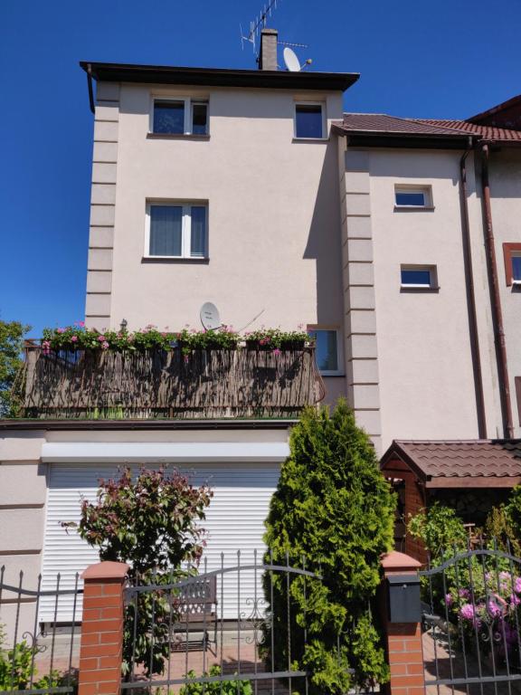 a building with a balcony with flowers on it at Pokoje Gościnne Alpinka in Ustka