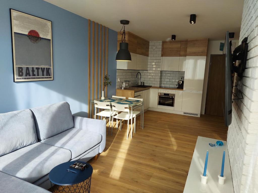 - un salon avec un canapé et une table dans l'établissement Apartament BALTIC BLUE, à Kołobrzeg