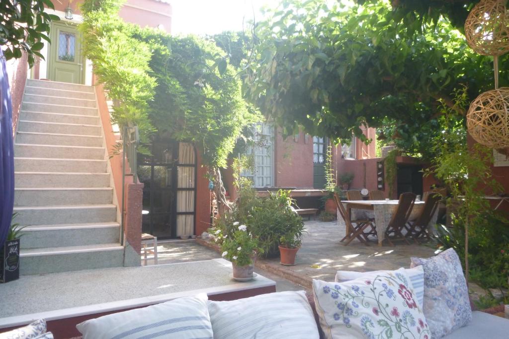 Small Guesthouse In The Garden في أمارنثوس: فناء مع أريكة وطاولة والدرج
