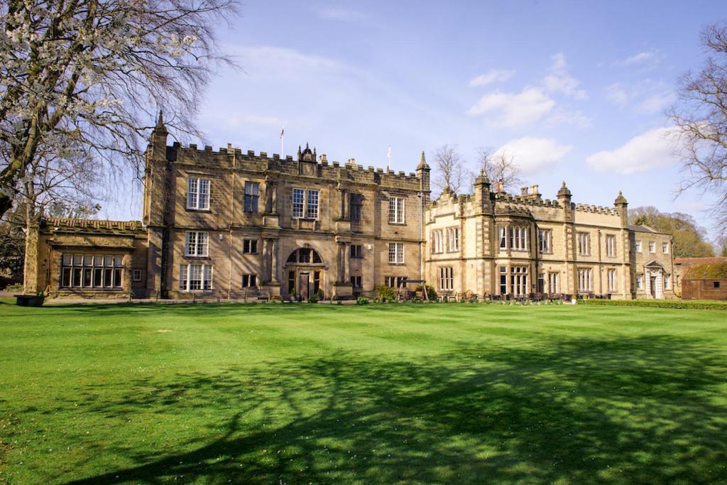 um velho castelo com um grande campo de relva em frente em The Old Lodge em Malton