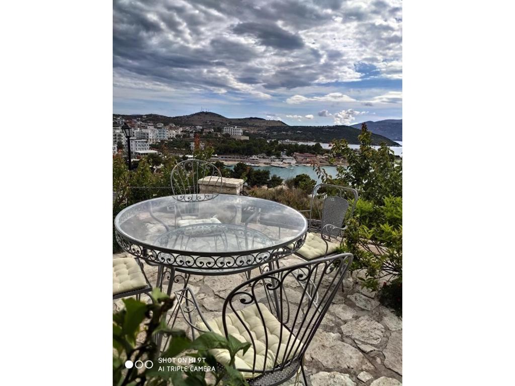 a table and chairs on a patio with a view at John's Guesthouse in Ksamil