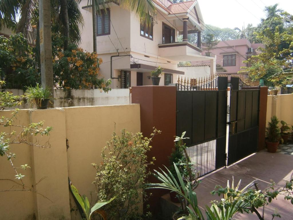 una cerca con una puerta negra delante de una casa en Lazar Residency Homestay, en Kochi