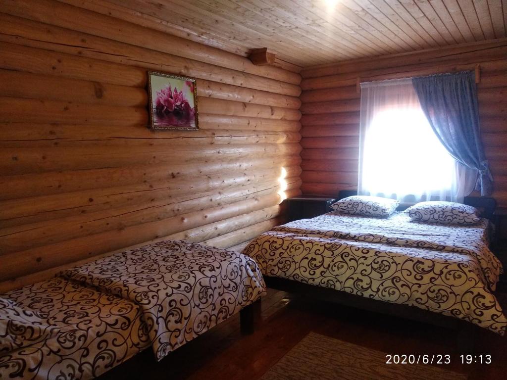 1 Schlafzimmer mit 2 Betten in einem Blockhaus in der Unterkunft Fiesta in Solotwyno
