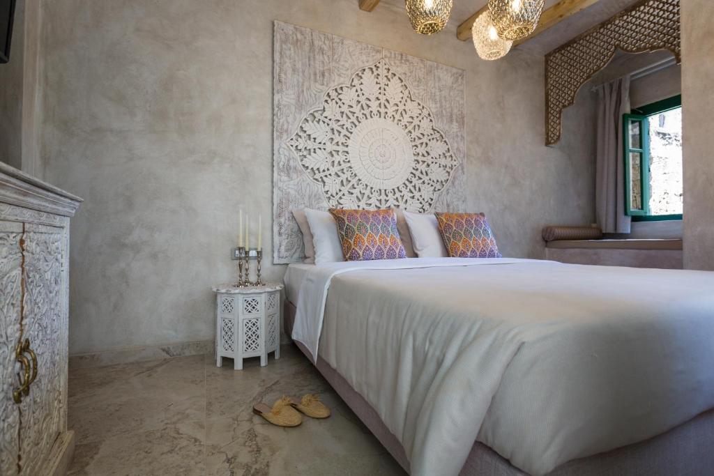 a bedroom with a large white bed and a fireplace at DECAN Concept Boutique Estate in Rhodes Town