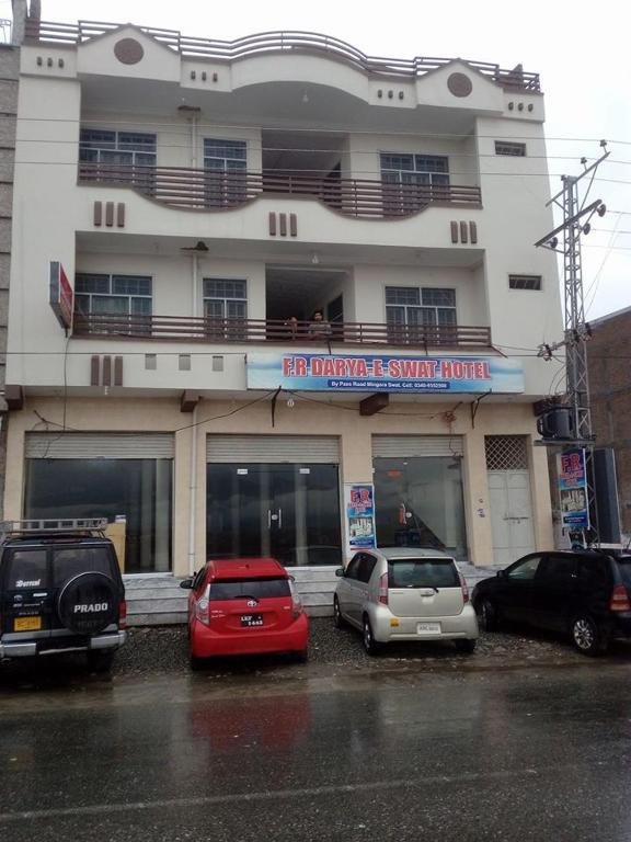 a group of cars parked in front of a building at FR Darya E Swat Hotel in Mingora