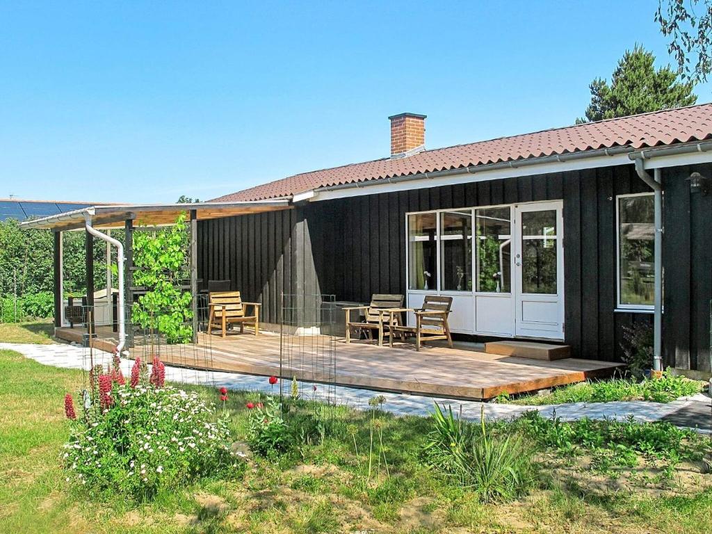 een huis met een terras met een tafel en stoelen bij Holiday home Rødby XLII in Rødby