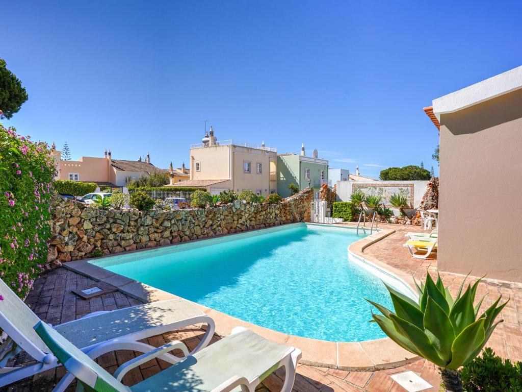 a swimming pool in a villa with a stone wall at Beautiful Holiday Home in Vilamoura with Private Pool in Vilamoura