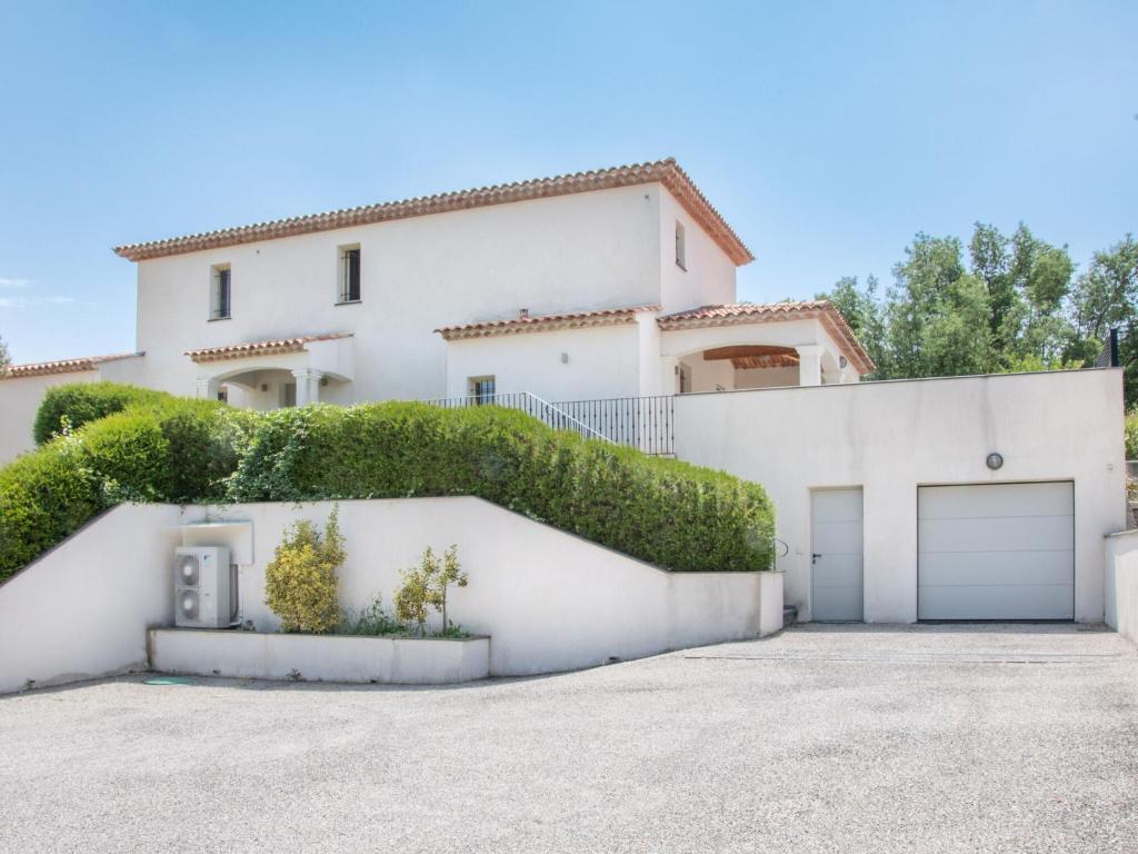 a large white house with a garage at Cosy villa with private pool in Emponse
