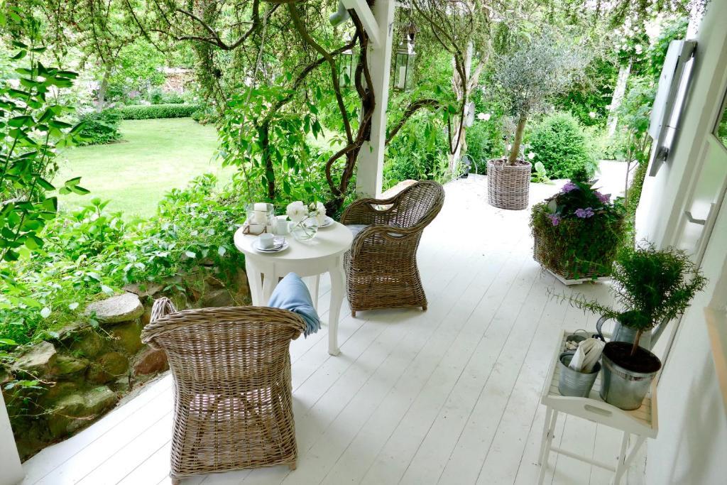 eine Terrasse mit einem Tisch und Stühlen auf einer Veranda in der Unterkunft Kleine Ferienwohnungen - Störtebeker in Ralswiek