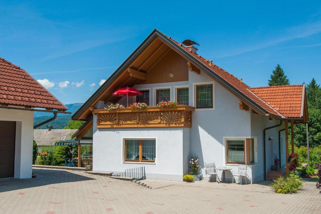 een huis met een balkon met een rood dak bij Ferienwohnung Ramsbacher in Velden am Wörthersee