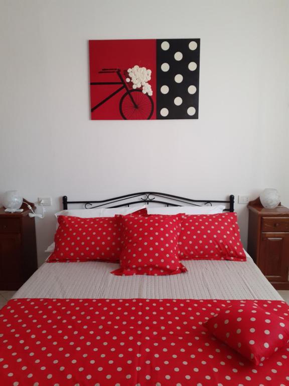 un letto con cuscini a pois rossi e bianchi di B&B MARZO '51 a Villasimius