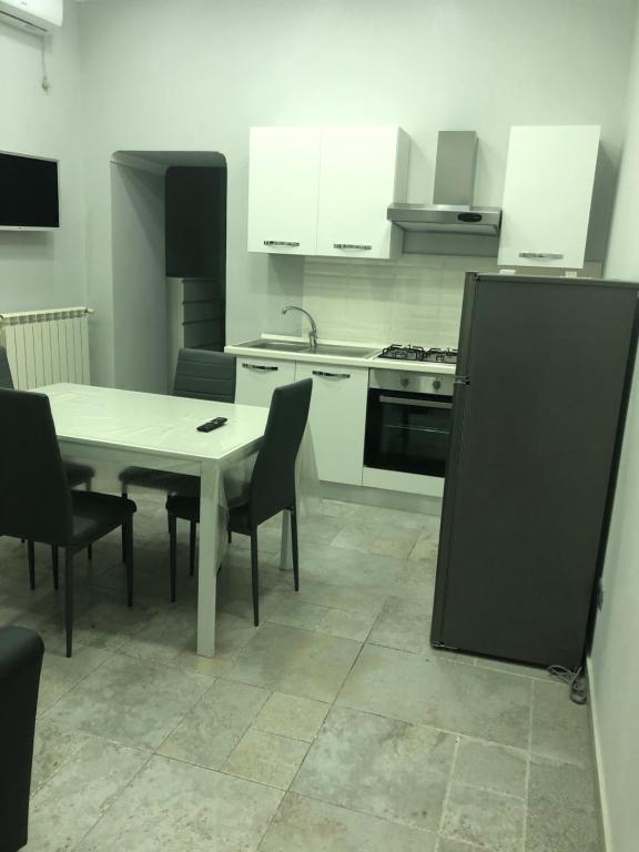 una cucina con tavolo, sedie e fornelli di CIKO HOME a Napoli