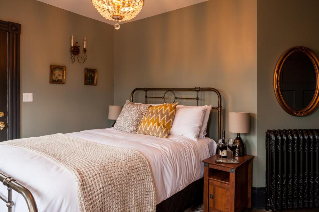 a bedroom with a bed and a table with a mirror at Slaymaker & Nichols Gastro House & Inn in Charlottetown