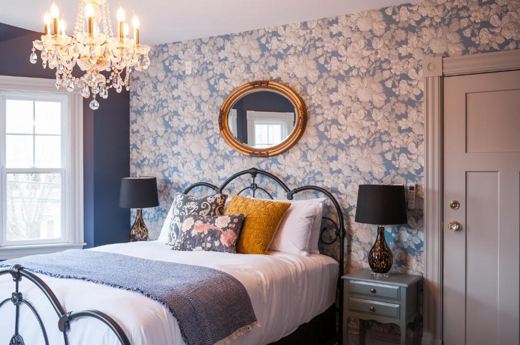 a bedroom with a bed with a blue floral wallpaper at Slaymaker & Nichols Gastro House & Inn in Charlottetown