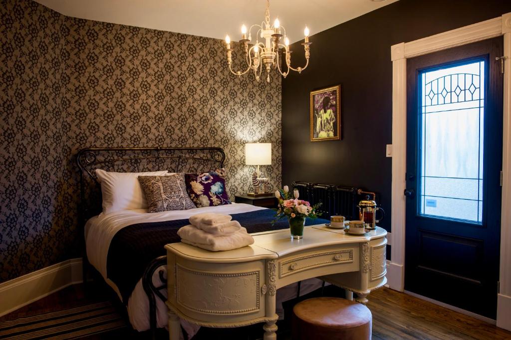 a bedroom with a bed and a table with towels on it at Slaymaker & Nichols Gastro House & Inn in Charlottetown