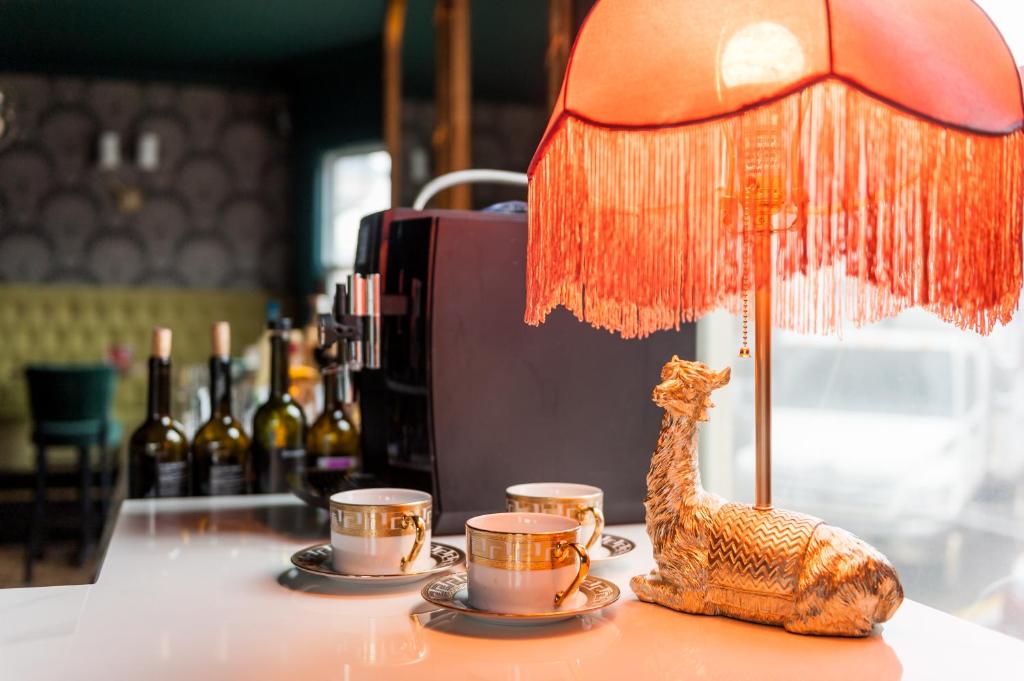 a giraffe figurine sitting on a table with three cups at Slaymaker & Nichols Gastro House & Inn in Charlottetown