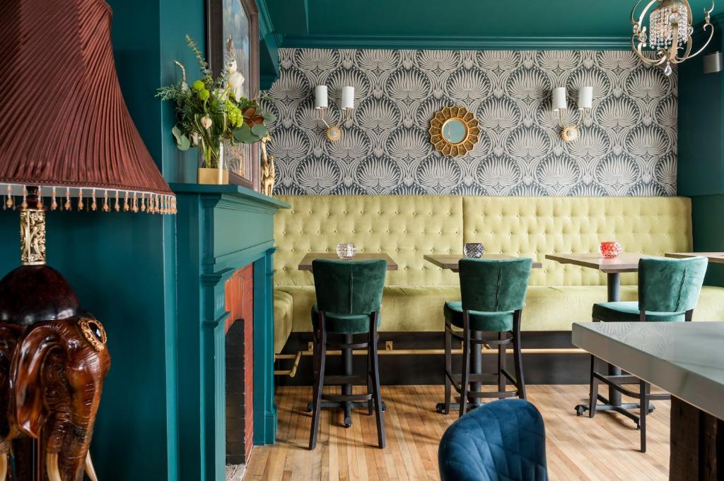 a restaurant with blue walls and green chairs at Slaymaker & Nichols Gastro House & Inn in Charlottetown