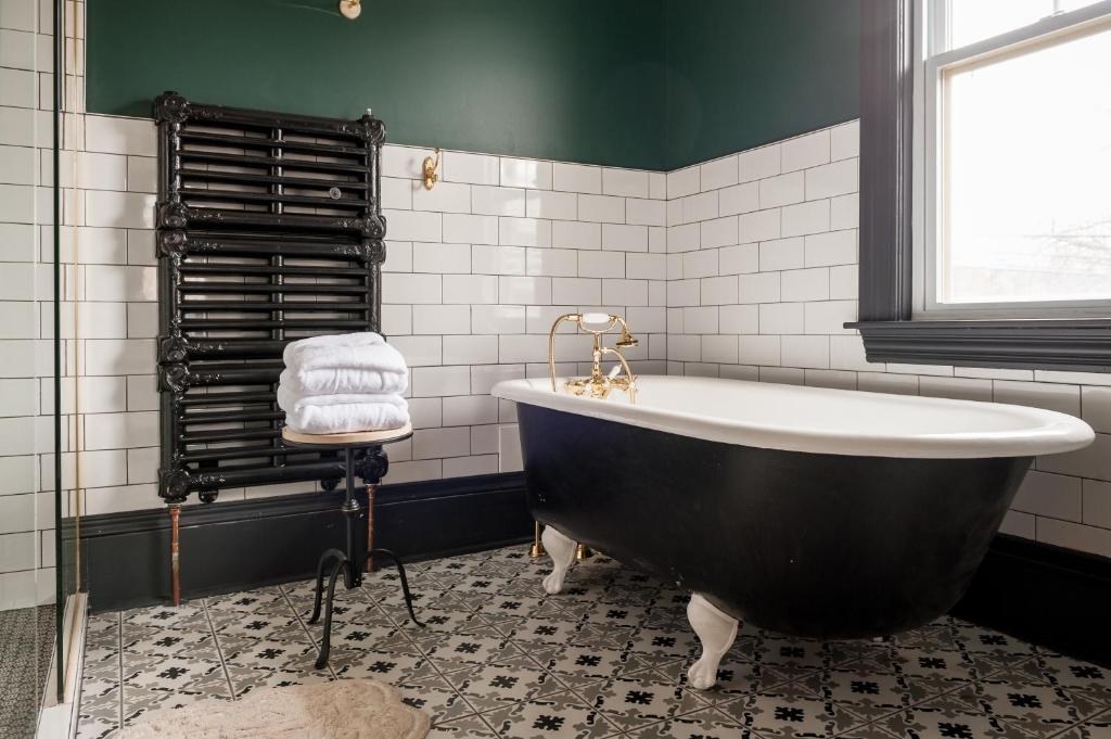 a black and white bathroom with a tub and a window at Slaymaker & Nichols Gastro House & Inn in Charlottetown
