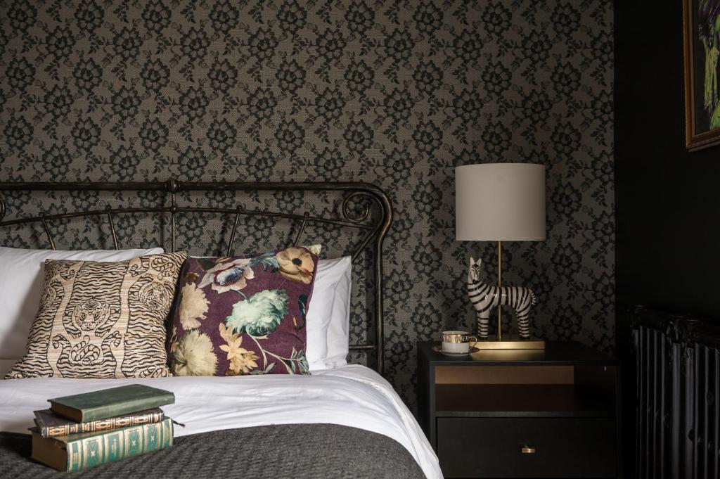 a bedroom with a bed and a table with a lamp at Slaymaker & Nichols Gastro House & Inn in Charlottetown
