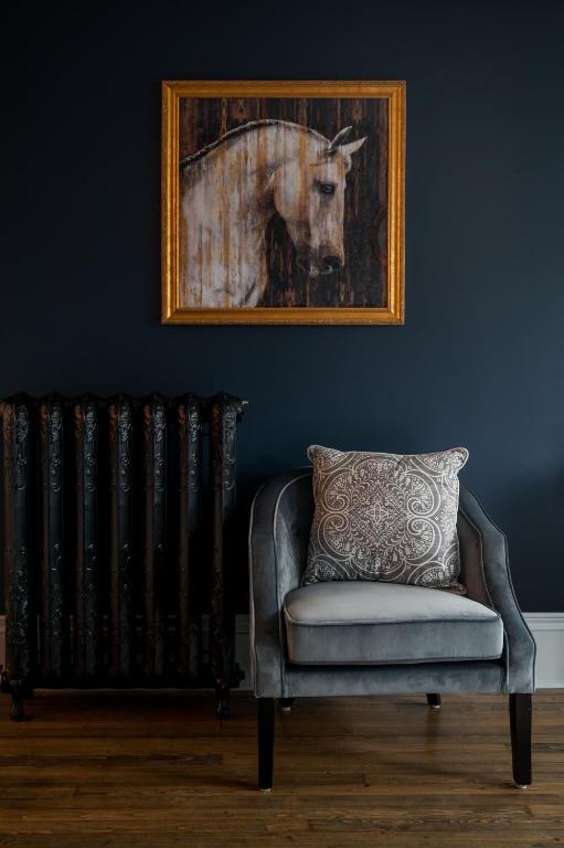 a painting of a horse on a wall next to a radiator at Slaymaker & Nichols Gastro House & Inn in Charlottetown