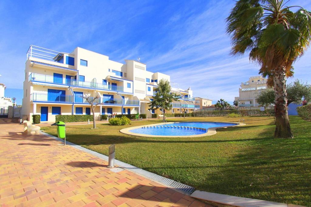 a large apartment building with a swimming pool in a park at Duplex Marina Golf B5 by costablancarent in Oliva