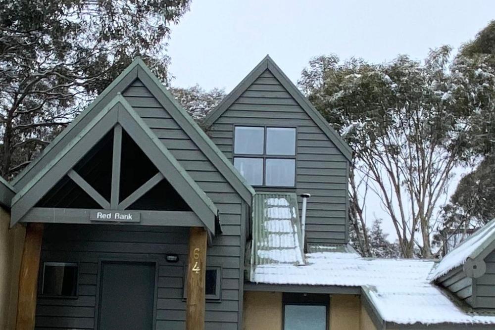 szary dom ze śniegiem na dachu w obiekcie Redbank w mieście Dinner Plain