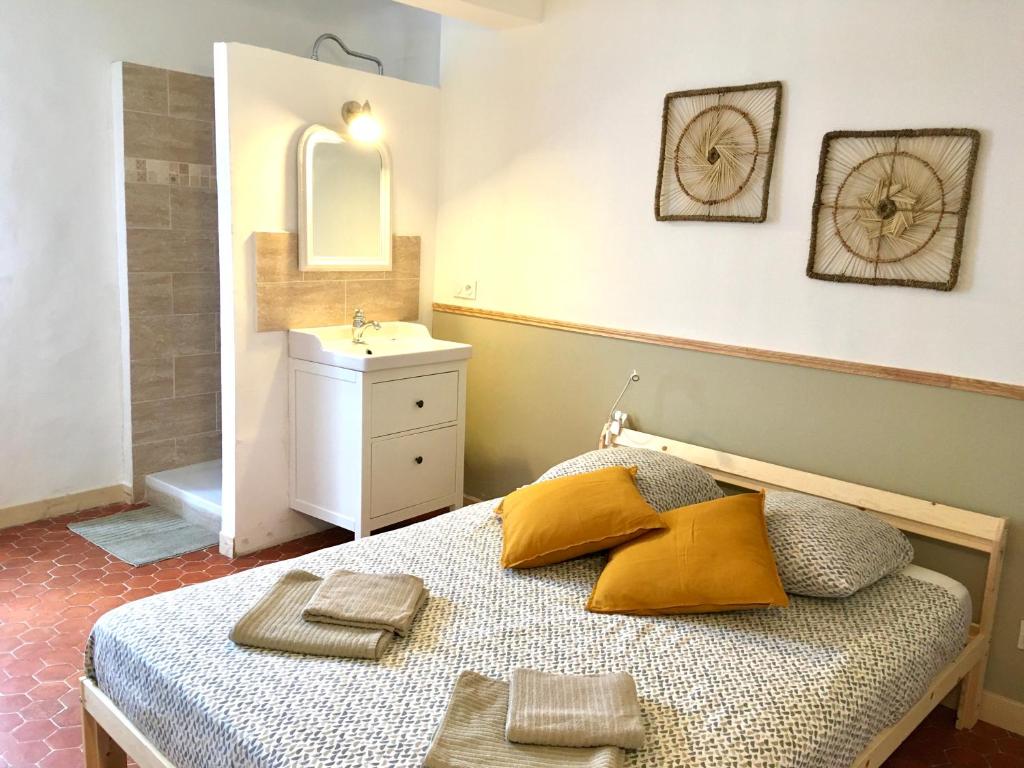 1 dormitorio con cama con lavabo y espejo en L'Escapade LORGUES, en Lorgues
