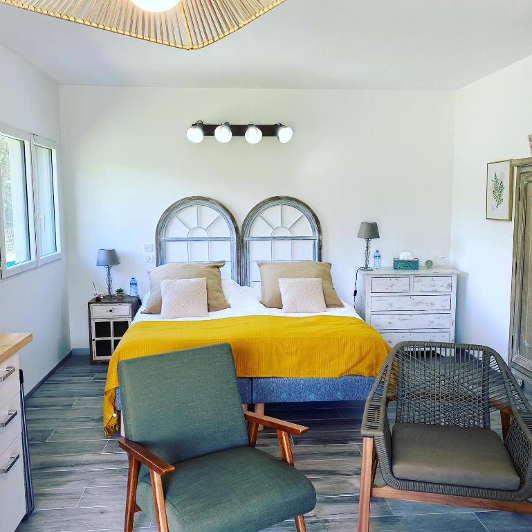 サン・ボネ・アン・シャンソールにある"Le Cottage" Appartements avec SPA privatifのベッドルーム1室(大型ベッド1台、椅子2脚付)