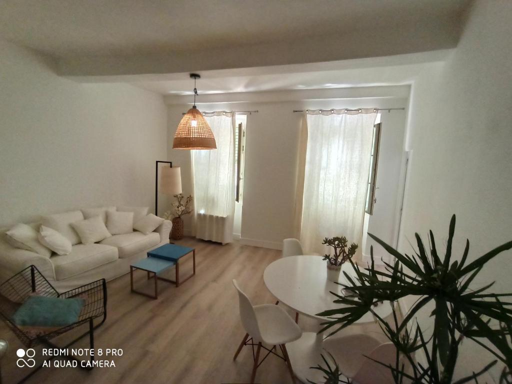 sala de estar con sofá blanco y mesa en Joli appartement niçois en bord de mer en Niza