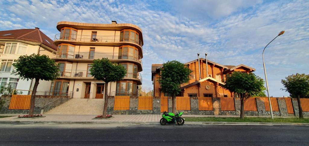 a green motorcycle parked in front of a house at Guest House Matrioshka in Lazarevskoye