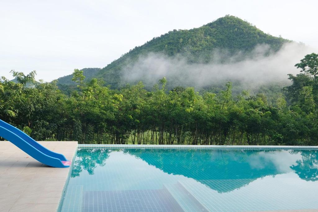 a swimming pool with a mountain in the background at Hi-scene Resort in Suan Phung