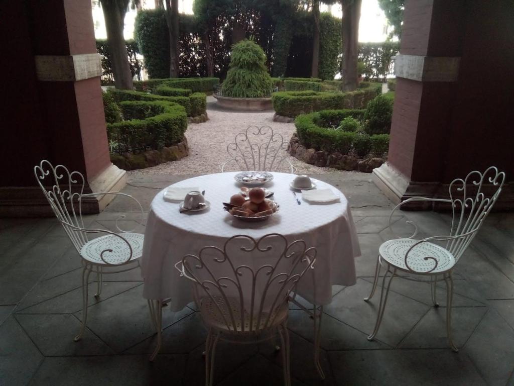 a table and chairs in a garden with bushes at Casa S. Giuseppe di Cluny in Rome