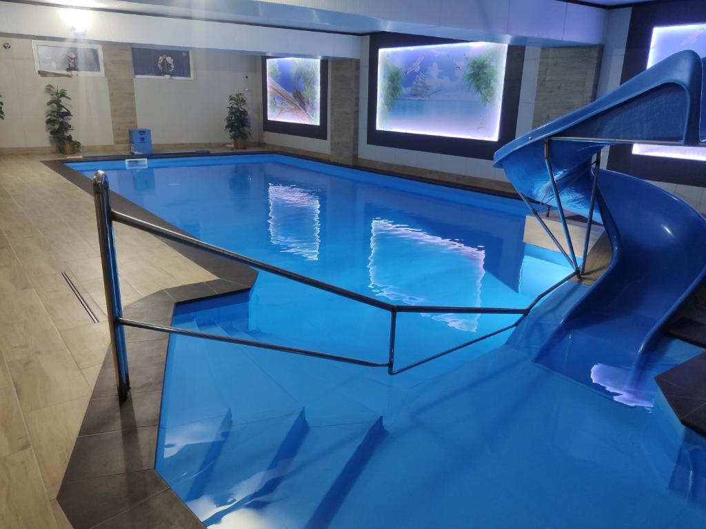 a swimming pool with a slide in a building at OW Sargus in Władysławowo