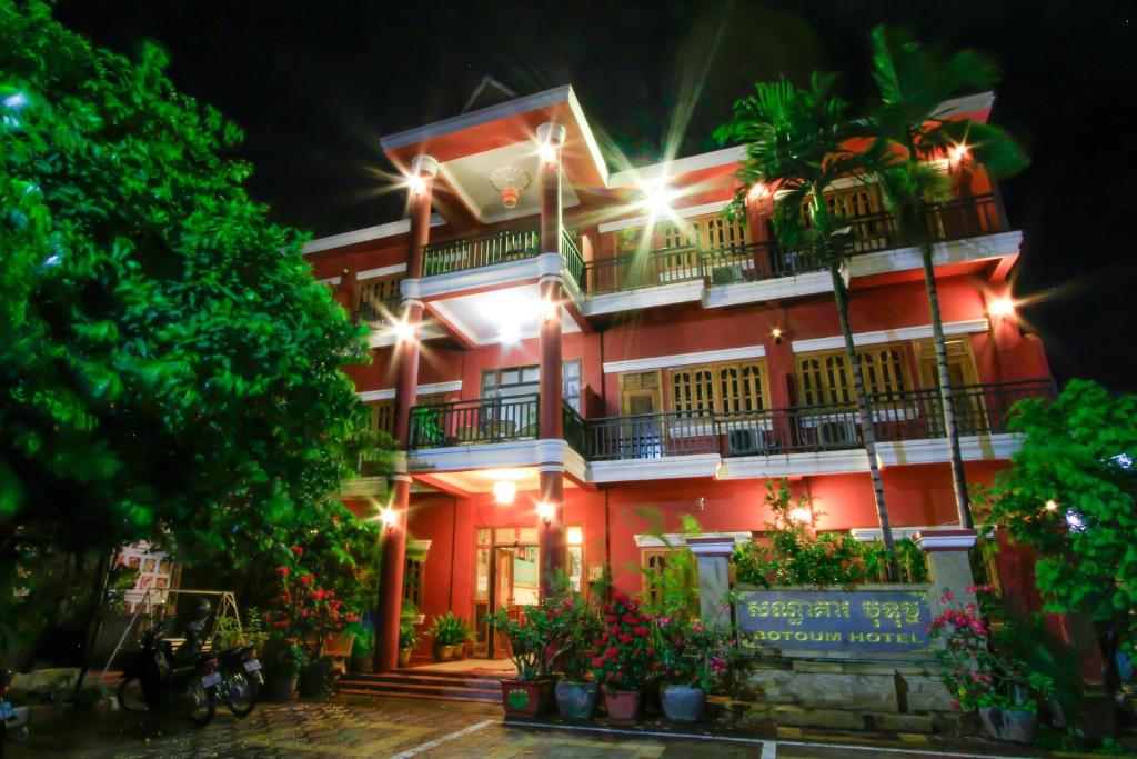 a large red building with lights on it at Botoum Hotel in Sisophon 
