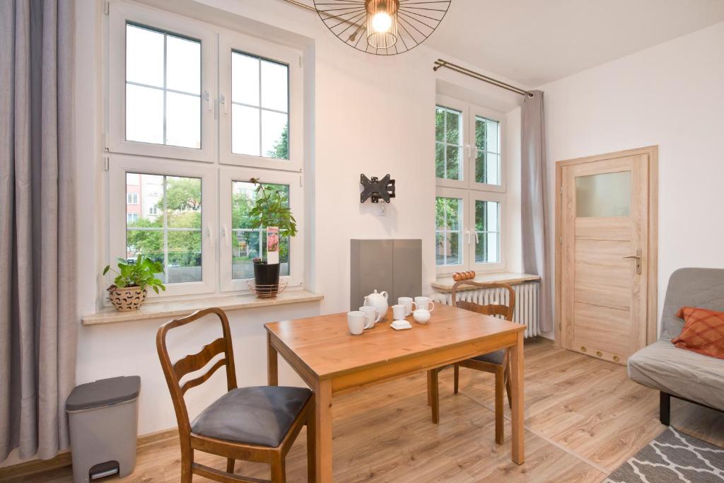 sala de estar con mesa de madera y sillas en YOURAPART Ogarna en Gdansk