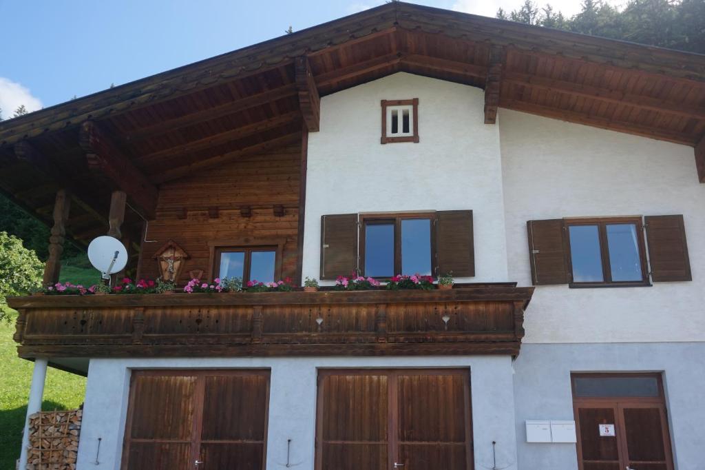 a house with a balcony with flowers on it at Berghaus Alberta in Michelsberg