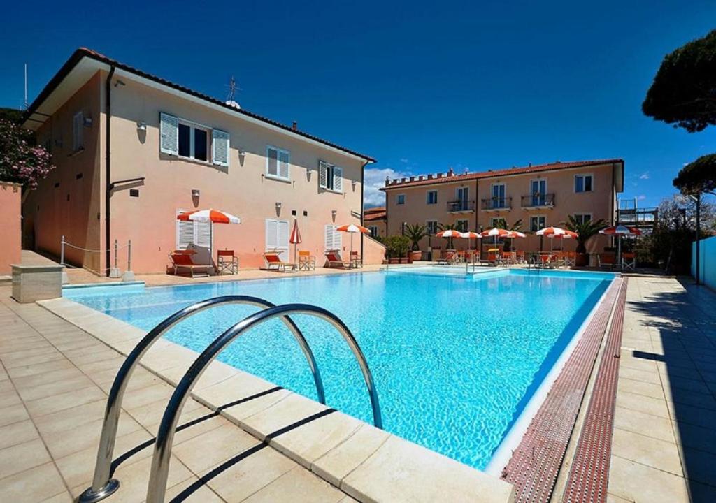 a large swimming pool next to a building at Bolgheri Marina Resort in Marina di Bibbona