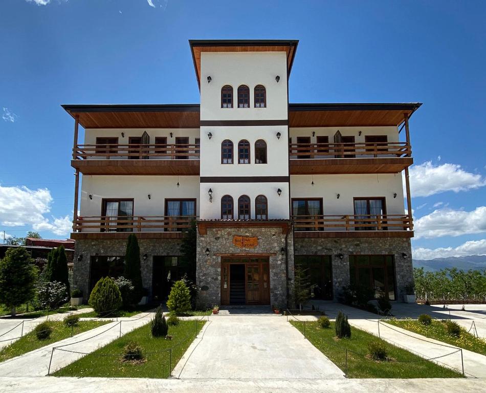un gran edificio con un balcón en la parte superior. en Nëna Dashuri Agroturizëm, en Peshkopi