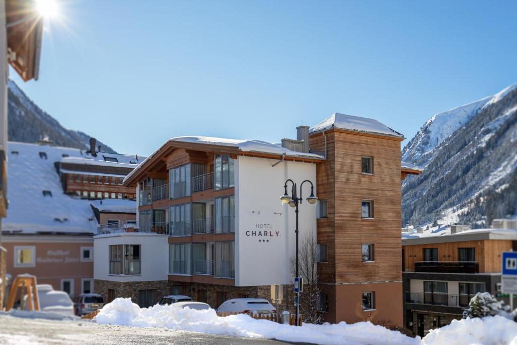 um edifício na neve com montanhas ao fundo em Hotel Charly em Ischgl