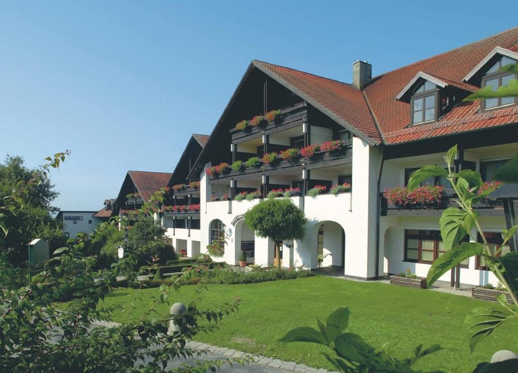 a large white building with flowers on the windows at Appartementhotel Griesbacher Hof in Bad Griesbach