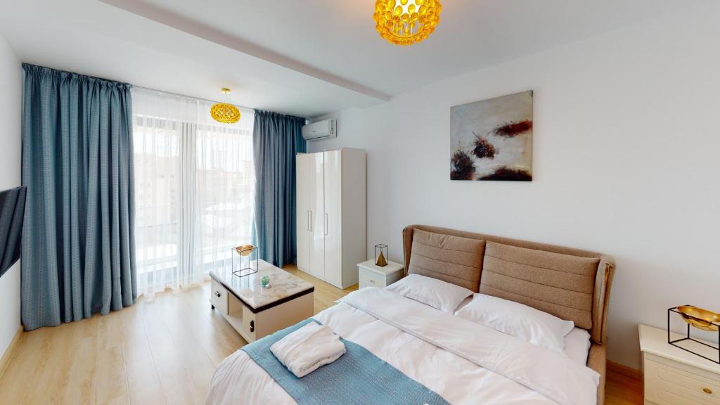 a bedroom with a large bed with blue curtains at Le Blanc ApartHotel in Bucharest