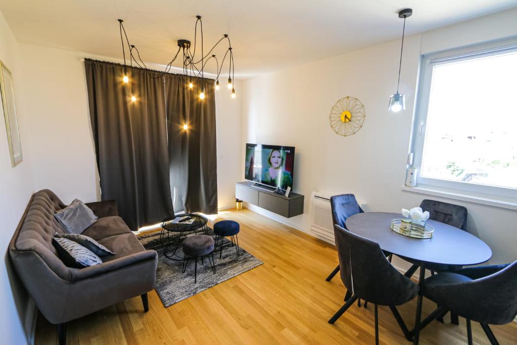 a living room with a couch and a table at Luce Gold Apartment in Zadar