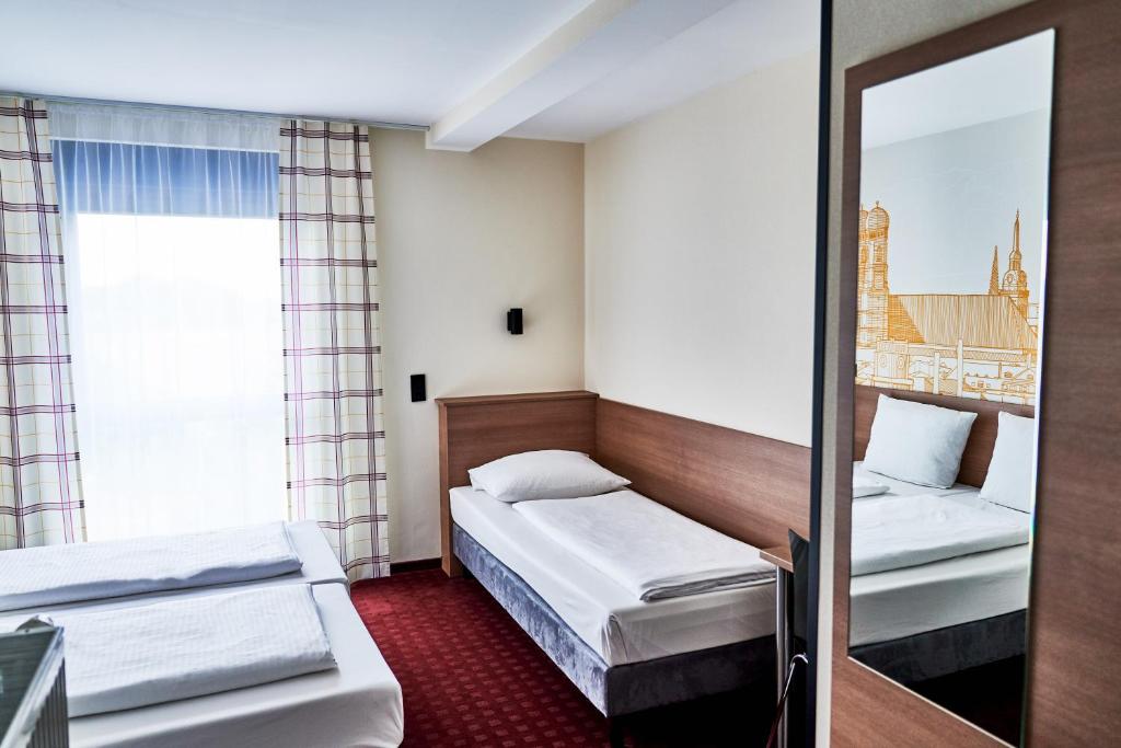 Postel nebo postele na pokoji v ubytování McDreams Hotel München - Messe