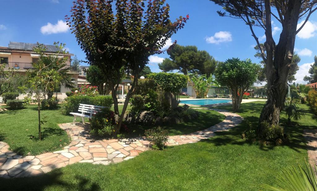 een park met een bankje en een zwembad bij ABLA Guest House in Carcavelos
